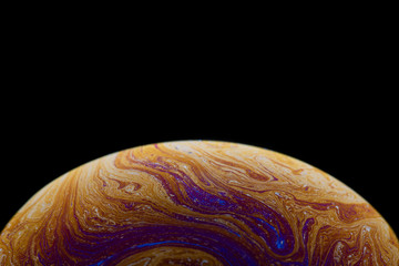 Burbuja de jabón simulando la atmosfera de un planeta con diferentes formas, colores y el fondo negro © Edgar1 BJ