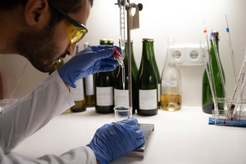 Close up of lab technician by placing a sample on beaker.