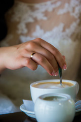 Hand of the bride and coffee

