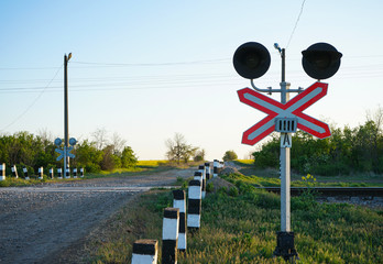 Railroad crossing against the blue sky. Railway traffic light at a railway crossing in Ukraine.