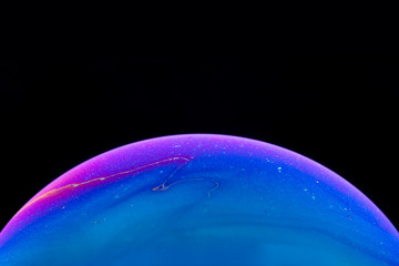 Burbuja de jabón simulando la atmosfera de un planeta con diferentes formas, colores y el fondo negro
