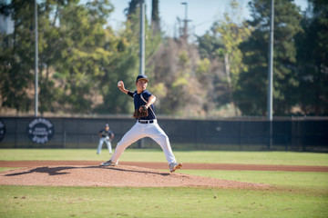 Baseball pitcher throwing ball on baseball field