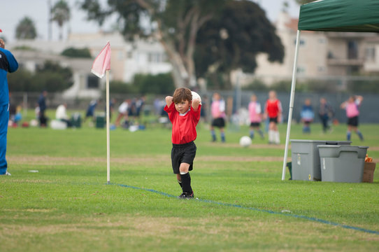 Young boy about to do a throw in on a soccer field