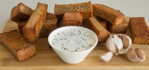 Fried breadcrumbs and garlic sauce with dill in a white Cup close up