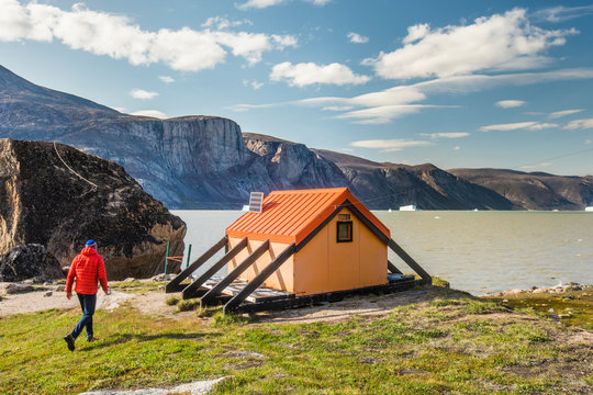 Alpinist approaches emergency shelter at North Pangnirtung Fiord