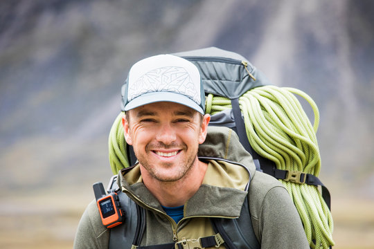 Portrait of climber wearing backpack, rope and GPS communication tool