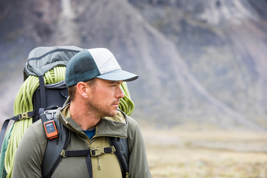 Portrait of determined backpacker carrying rope and navigation devie