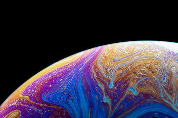 Burbuja de jabón simulando la atmosfera de un planeta con diferentes formas, colores y el fondo negro © Edgar1 BJ