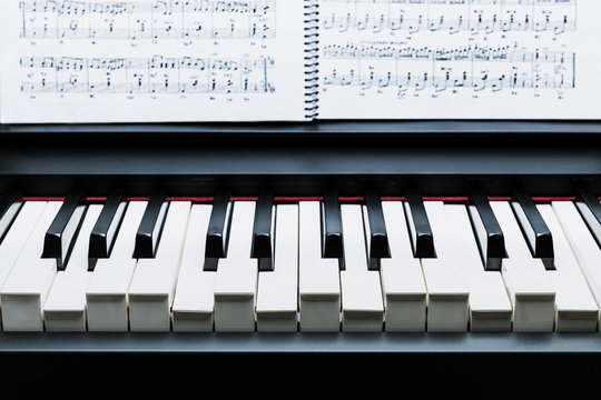 Black and white keys on a electronic piano pulsing an A Chord
