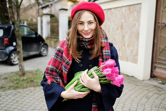 young french millennial girl in beret and coat with tulips in hands