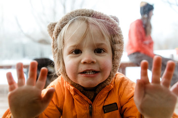 young girl with animal hoodie looks at camera, pushes against window