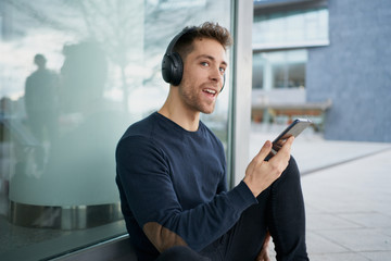 Young man with headphones on city street