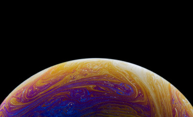 Burbuja de jabón simulando la atmosfera de un planeta con diferentes formas, colores y el fondo negro © Edgar1 BJ