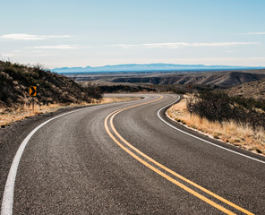 a deserted road winds through the desert near Arrey, New Mexico