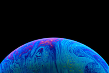 Burbuja de jabón simulando la atmosfera de un planeta con diferentes formas, colores y el fondo negro © Edgar1 BJ