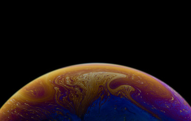 Burbuja de jabón simulando la atmosfera de un planeta con diferentes formas, colores y el fondo negro