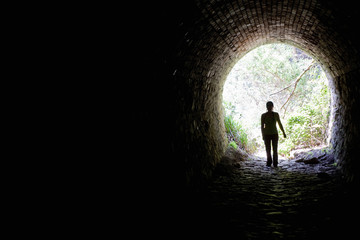 Woman standing in a tunnel opening
