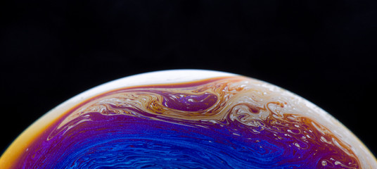 Burbuja de jabón simulando la atmosfera de un planeta con diferentes formas, colores y el fondo negro © Edgar1 BJ