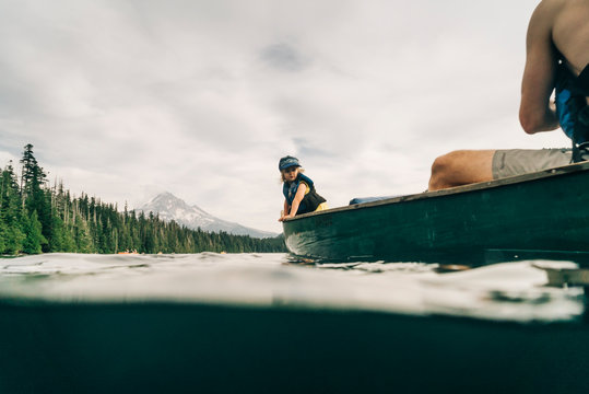 A young girl rides in a canoe with her dad on Lost Lake in Oregon.