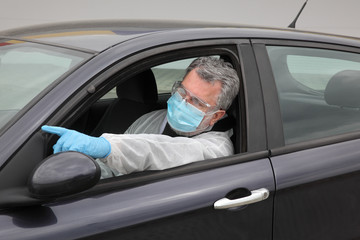 Protected driver in car wearing glasses, mask and gloves gesturing, pointing, corona virus protection