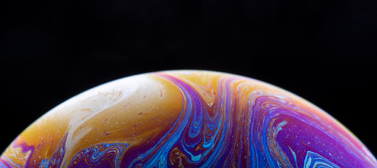 Burbuja de jabón simulando la atmosfera de un planeta con diferentes formas, colores y el fondo negro © Edgar1 BJ