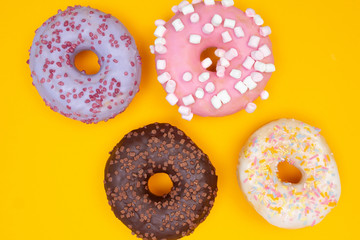 Sweet chocolate donut on yellow background. Dessert food