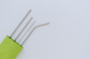 Reusable stainless steel straws tubes and cotton bag on white background with copy space. Flat lay eco-friendly lifestyle