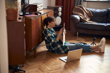 Attractive guy holding vinyl record while resting at home