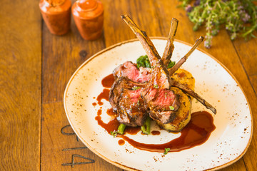grilled Australian lamb rack with roasted sweet potatoes, charred broccolini and pomegranate demi-glace