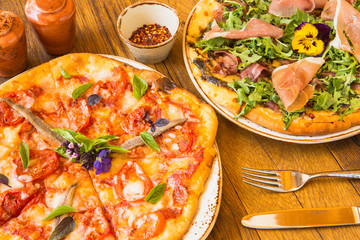 margherita pizza and a proscuitto and arugula pizza