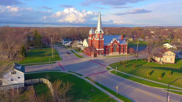 Dramatic dusk clouds over peaceful small town with church at sunset.