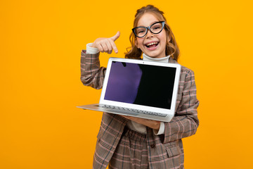funny beautiful girl in a classic jacket holds a laptop with the screen forward with the layout