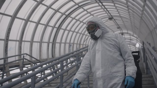Worker disinfects the railing of the pedestrian bridge