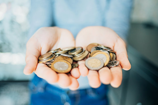 a handful of coins in female hands.