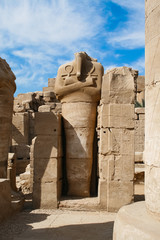 ruined headless statue in the guise of god Osiris in Karnak Temple Complex