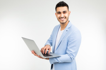 smiling office worker man with an open laptop in his hands on a white studio background