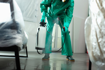 Specialist chlorinating the room in protective uniform stock photo