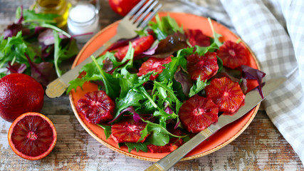 Selective focus. Macro. Healthy vegan mix salad with red oranges. Refreshing detox salad. Bloody orange. Cooking healthy food at home.
