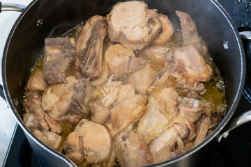 Chicken stewed meat in a pan. Rustic homemade stew meat. Top view with smoke. Cook at home.