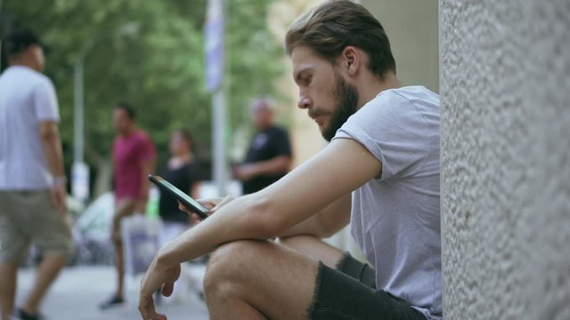 Young Man Checking Smartphone Outdoors