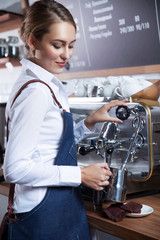  young barista girl makes coffee