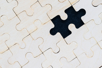 Close up wooden jigsaw puzzle pieces on black background