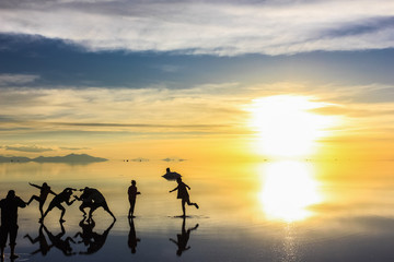 Fototapeta na wymiar silhouettes of people playing on water mirror