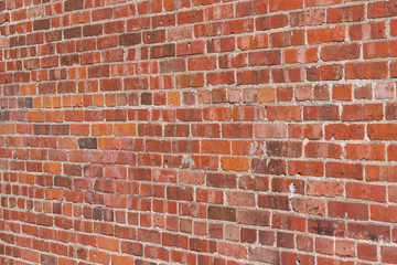 Antique exterior red clay brick wall background with severely decaying brick texture and mortar