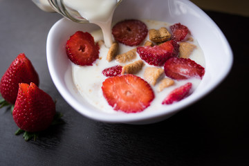 Cereals with strawberries and milk as breakfast