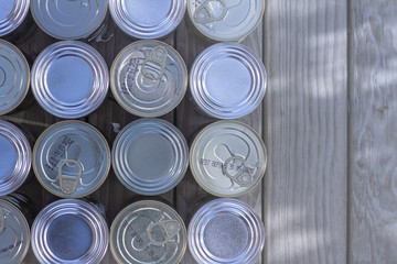 A neatly organised selection of un-labelled tinned foods. 