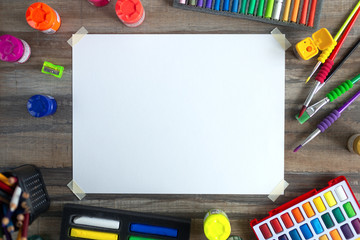 Stationary, flat lay top view of art workplace, colored pencils, cope space paper and crayon pastel chalks.