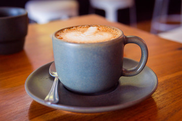 Cup of coffee on a wooden table. Hot cappuccino