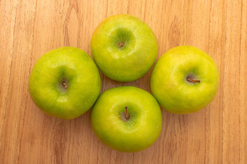 four green apples on wooden table. Healthy food. Fresh fruits.