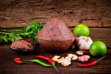 shrimp paste ( kapi ) and ingredient on brown wood texture background.
